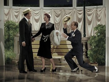 Movie still from “Holiday Inn” (1942), directed by Robert Allen – A group of men and women dressed in suits and hats; Wide shot, High angle