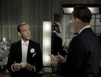 Movie still from “Holiday Inn” (1942), directed by Robert Allen – A man in a tuxedo is looking at himself in the mirror; Medium shot, Over the shoulder angle