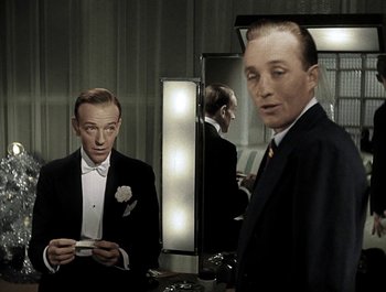 Movie still from “Holiday Inn” (1942), directed by Robert Allen – A man standing in front of a mirror holding a cell phone; Medium shot, High angle