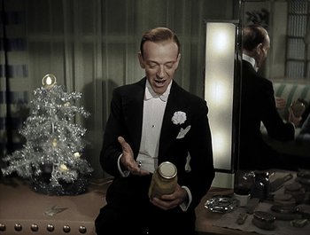 Movie still from “Holiday Inn” (1942), directed by Robert Allen – A man in a tuxedo is holding a glass of champagne; Medium shot, High angle