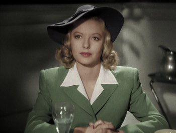 Movie still from “Holiday Inn” (1942), directed by Robert Allen – A woman wearing a green suit and a black hat; Medium shot, Low angle