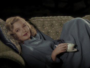 Movie still from “Holiday Inn” (1942), directed by Robert Allen – A woman is sitting on a couch holding a cup of coffee; Medium shot, High angle