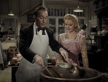 Movie still from “Holiday Inn” (1942), directed by Robert Allen – A man and a woman preparing food in a kitchen; Medium shot, High angle