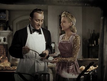 Movie still from “Holiday Inn” (1942), directed by Robert Allen – A man and a woman are cooking in a kitchen; Medium shot, High angle