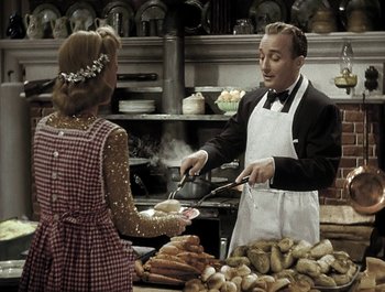 Movie still from “Holiday Inn” (1942), directed by Robert Allen – A man and a woman in a kitchen preparing food; Medium shot, High angle