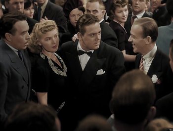 Movie still from “Holiday Inn” (1942), directed by Robert Allen – A group of people standing around each other in a room; Medium shot, High angle