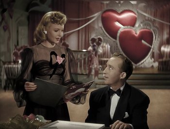 Movie still from “Holiday Inn” (1942), directed by Robert Allen – A man and a woman sitting at a dinner table; Medium shot, High angle