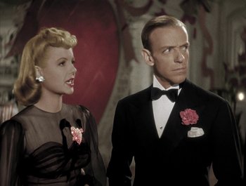 Movie still from “Holiday Inn” (1942), directed by Robert Allen – A man and a woman standing next to each other in formal wear; Close Up shot, Over the shoulder angle