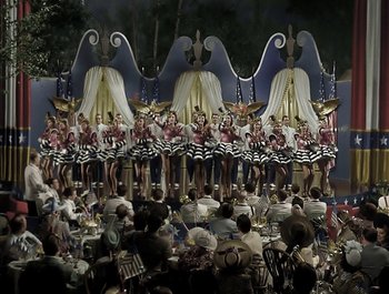 Movie still from “Holiday Inn” (1942), directed by Robert Allen – A crowd of people sitting and standing in front of a stage; Extreme Wide shot, High angle