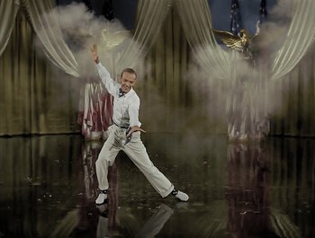 Movie still from “Holiday Inn” (1942), directed by Robert Allen – A man in white shirt and white pants holding a sword; Wide shot, Low angle