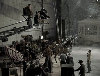 Movie still from “Holiday Inn” (1942), directed by Robert Allen – A group of people standing next to each other on a street; Extreme Wide shot, High angle