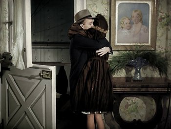 Movie still from “Holiday Inn” (1942), directed by Robert Allen – A man and a woman hugging in front of a painting; Wide shot, High angle
