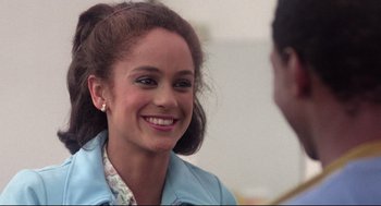 Movie still from “Hollywood Shuffle” (1987), directed by Robert Townsend – A young woman smiles at the camera as she talks to a man; Close Up shot, Over the shoulder angle
