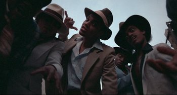 Movie still from “Hollywood Shuffle” (1987), directed by Robert Townsend – A group of men in suits and hats are posing for a picture; Close Up shot, Low angle