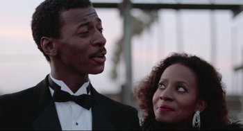 Movie still from “Hollywood Shuffle” (1987), directed by Robert Townsend – A man and a woman standing next to each other; Close Up shot, Low angle