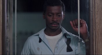 Movie still from “Hollywood Shuffle” (1987), directed by Robert Townsend – A man in a white shirt and a tie; Close Up shot, Over the shoulder angle