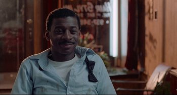 Movie still from “Hollywood Shuffle” (1987), directed by Robert Townsend – A person wearing a shirt and a tie; Close Up shot, Over the shoulder angle