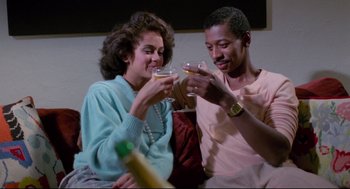 Movie still from “Hollywood Shuffle” (1987), directed by Robert Townsend – A man and a woman holding wine glasses and smiling; Medium shot, Low angle
