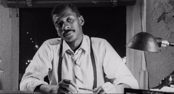 Movie still from “Hollywood Shuffle” (1987), directed by Robert Townsend – An old black and white photo of a man wearing a tie; Close Up shot, Low angle