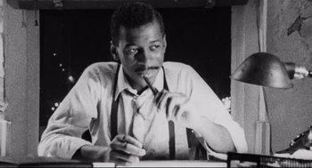 Movie still from “Hollywood Shuffle” (1987), directed by Robert Townsend – A black and white photo of a man smoking a cigarette; Close Up shot, Low angle
