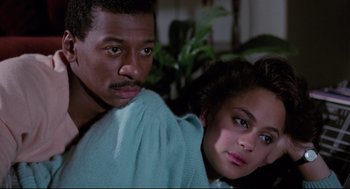 Movie still from “Hollywood Shuffle” (1987), directed by Robert Townsend – A man and a woman sitting next to each other; Close Up shot, High angle