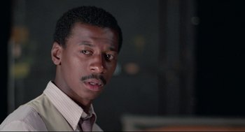 Movie still from “Hollywood Shuffle” (1987), directed by Robert Townsend – A person wearing a suit and tie; Close Up shot, Low angle