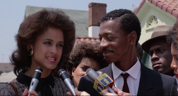 Movie still from “Hollywood Shuffle” (1987), directed by Robert Townsend – A man and a woman are being interviewed by a reporter; Close Up shot, Over the shoulder angle