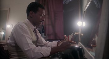 Movie still from “Hollywood Shuffle” (1987), directed by Robert Townsend – A man sitting in front of a laptop computer; Medium shot, Low angle
