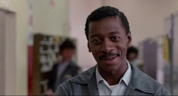Movie still from “Hollywood Shuffle” (1987), directed by Robert Townsend – A person wearing a jacket and smiling; Close Up shot, Low angle