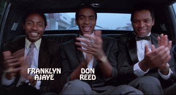 Movie still from “Hollywood Shuffle” (1987), directed by Robert Townsend – A group of men sitting in the back of a car; Medium shot, Low angle