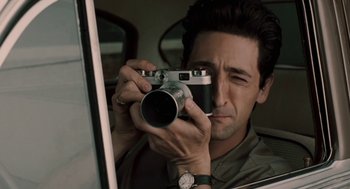 Movie still from “Hollywoodland” (2006), directed by Allen Coulter – A person taking a picture with a camera; Close Up shot, High angle