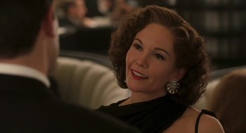 Movie still from “Hollywoodland” (2006), directed by Allen Coulter – A woman in a black dress smiling for the camera; Close Up shot, Over the shoulder angle