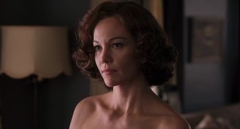 Movie still from “Hollywoodland” (2006), directed by Allen Coulter – A woman with short brown curly hair is looking at the camera; Close Up shot, Over the shoulder angle