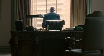 Movie still from “Hollywoodland” (2006), directed by Allen Coulter – A man sitting at a desk in front of a window; Wide shot, Low angle