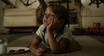 Movie still from “Hollywoodland” (2006), directed by Allen Coulter – A young boy laying on the floor with his hand under his chin; Close Up shot, High angle