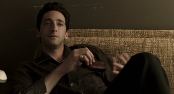 Movie still from “Hollywoodland” (2006), directed by Allen Coulter – A man sitting on a couch holding a remote control; Close Up shot, High angle