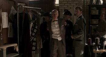 Movie still from “Hollywoodland” (2006), directed by Allen Coulter – A group of men standing next to each other in a room; Medium shot, Over the shoulder angle
