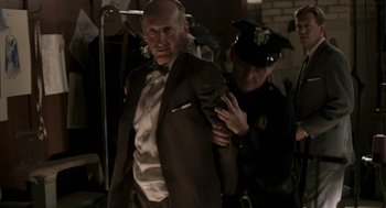 Movie still from “Hollywoodland” (2006), directed by Allen Coulter – A man in a suit and a police officer in a uniform; Medium shot, Over the shoulder angle