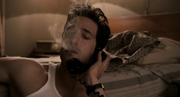 Movie still from “Hollywoodland” (2006), directed by Allen Coulter – A young man smoking a cigarette while talking on a phone; Close Up shot, High angle