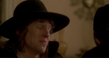 Movie still from “Holy Rollers” (2010), directed by Kevin Asch – A man wearing a black hat is sitting down; Close Up shot, High angle