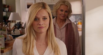 A woman standing next to another woman in a kitchen