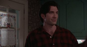 Movie still from “Home for the Holidays” (1995), directed by Jodie Foster – A man that is wearing a red and black checkered shirt; Medium shot, Over the shoulder angle