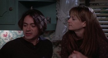 Movie still from “Home for the Holidays” (1995), directed by Jodie Foster – A man and a woman sitting next to each other in a room; Medium shot, Over the shoulder angle