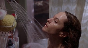 Movie still from “Home for the Holidays” (1995), directed by Jodie Foster – A woman is taking a shower in a bathroom; Close Up shot, Low angle