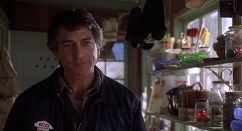 Movie still from “Home for the Holidays” (1995), directed by Jodie Foster – A person wearing a jacket in a room; Close Up shot, Over the shoulder angle