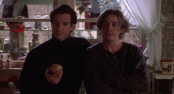 Movie still from “Home for the Holidays” (1995), directed by Jodie Foster – Two men standing next to each other holding an apple; Close Up shot, Low angle