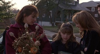 Movie still from “Home for the Holidays” (1995), directed by Jodie Foster – Two women and a girl looking at a bouquet of flowers; Medium shot, Over the shoulder angle
