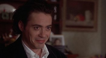 Movie still from “Home for the Holidays” (1995), directed by Jodie Foster – A person wearing a suit and smiling; Close Up shot, Over the shoulder angle
