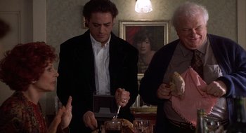 Movie still from “Home for the Holidays” (1995), directed by Jodie Foster – A group of people standing around a table with food on it; Medium shot, High angle