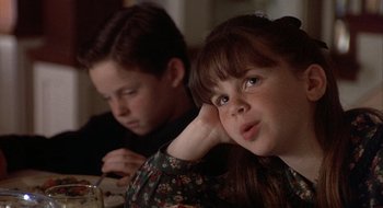 Movie still from “Home for the Holidays” (1995), directed by Jodie Foster – A young boy and a young girl sitting at a dinner table; Close Up shot, Over the shoulder angle